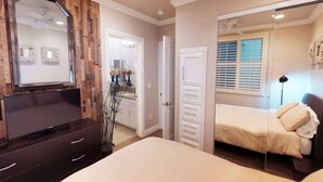 Un dormitorio con cama, cómoda, espejo y ventilador de techo.