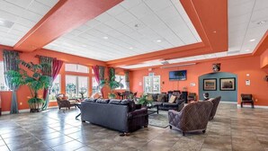 A spacious lobby with a large seating area, a reception desk, and a television mounted on the wall. - Oakwater - Spacious 3BR 2.5BA townhome, gated (Kissimmee)