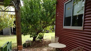 A patio with a brick floor, a metal table, and two wicker chairs. - THE STABLE WILLYUNG WA (Willyung)