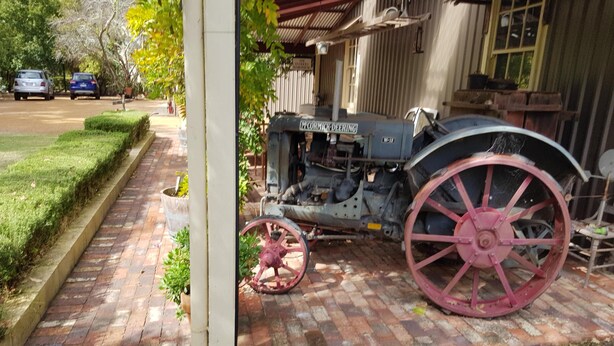 A vintage tractor parked on a brick pathway with a building in the background. - THE STABLE WILLYUNG WA (Willyung)