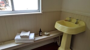 A bathroom with a wooden bench, a yellow sink, and a window. - THE STABLE WILLYUNG WA (Willyung)