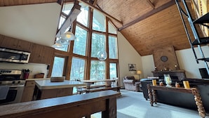 A spacious kitchen with wooden cabinets, a large island, and a dining area with a bench. - Ski-in Ski-out Killington Chalet on Great Eastern Trail, Huge Loft + 4 Bedrooms (Killington)
