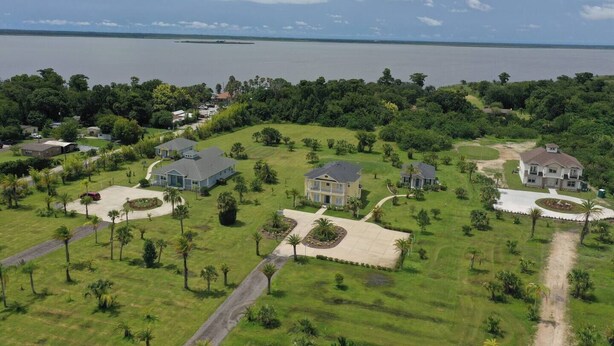 Un quartier résidentiel avec des maisons, des rues et une étendue d’eau en arrière-plan.