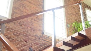 Una escalera con barandilla de metal que lleva a un segundo piso.