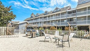 A multi-story hotel with outdoor seating and barbecue grills.