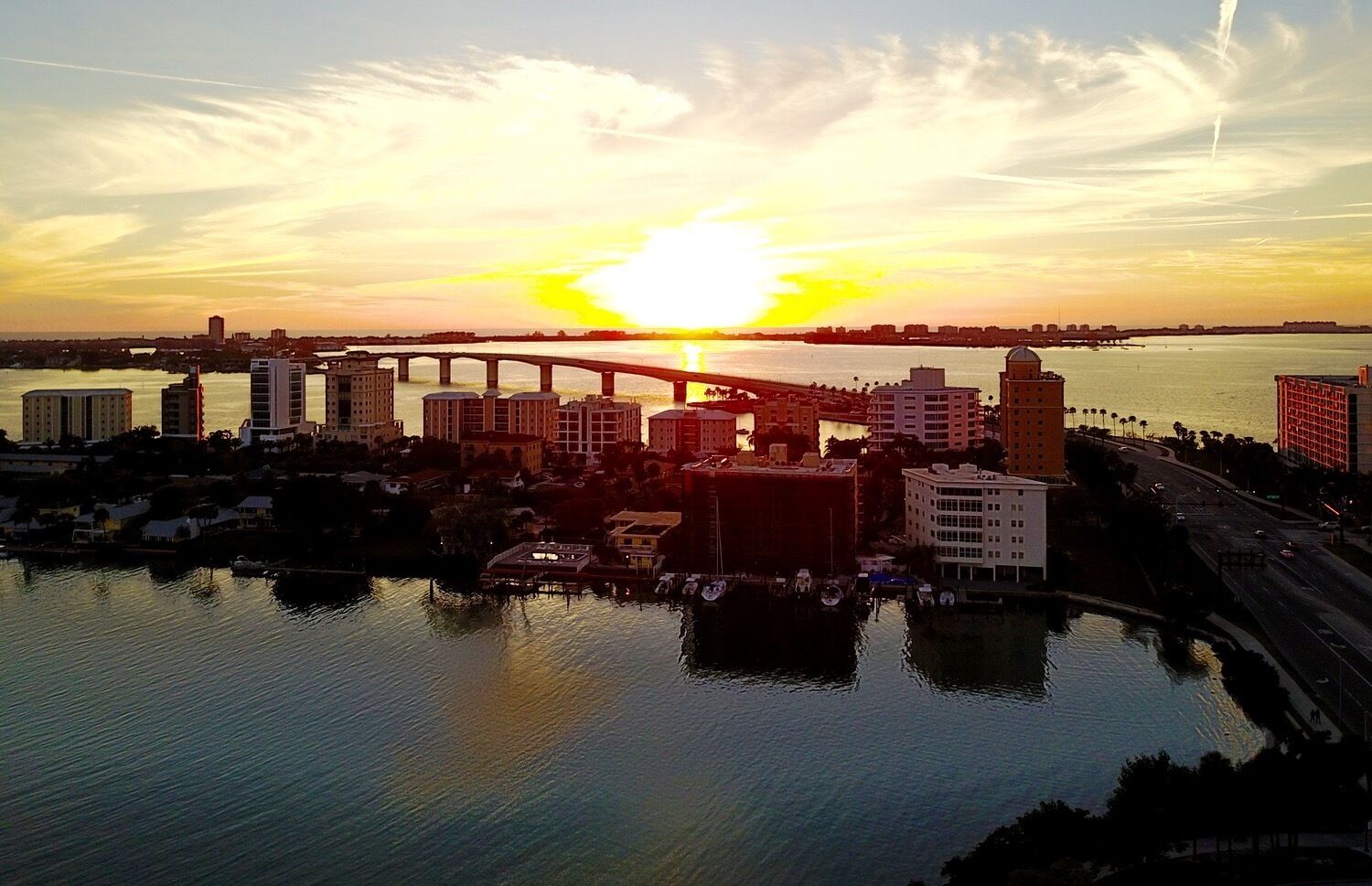 Un horizonte urbano al atardecer con un puente, edificios y una ribera.