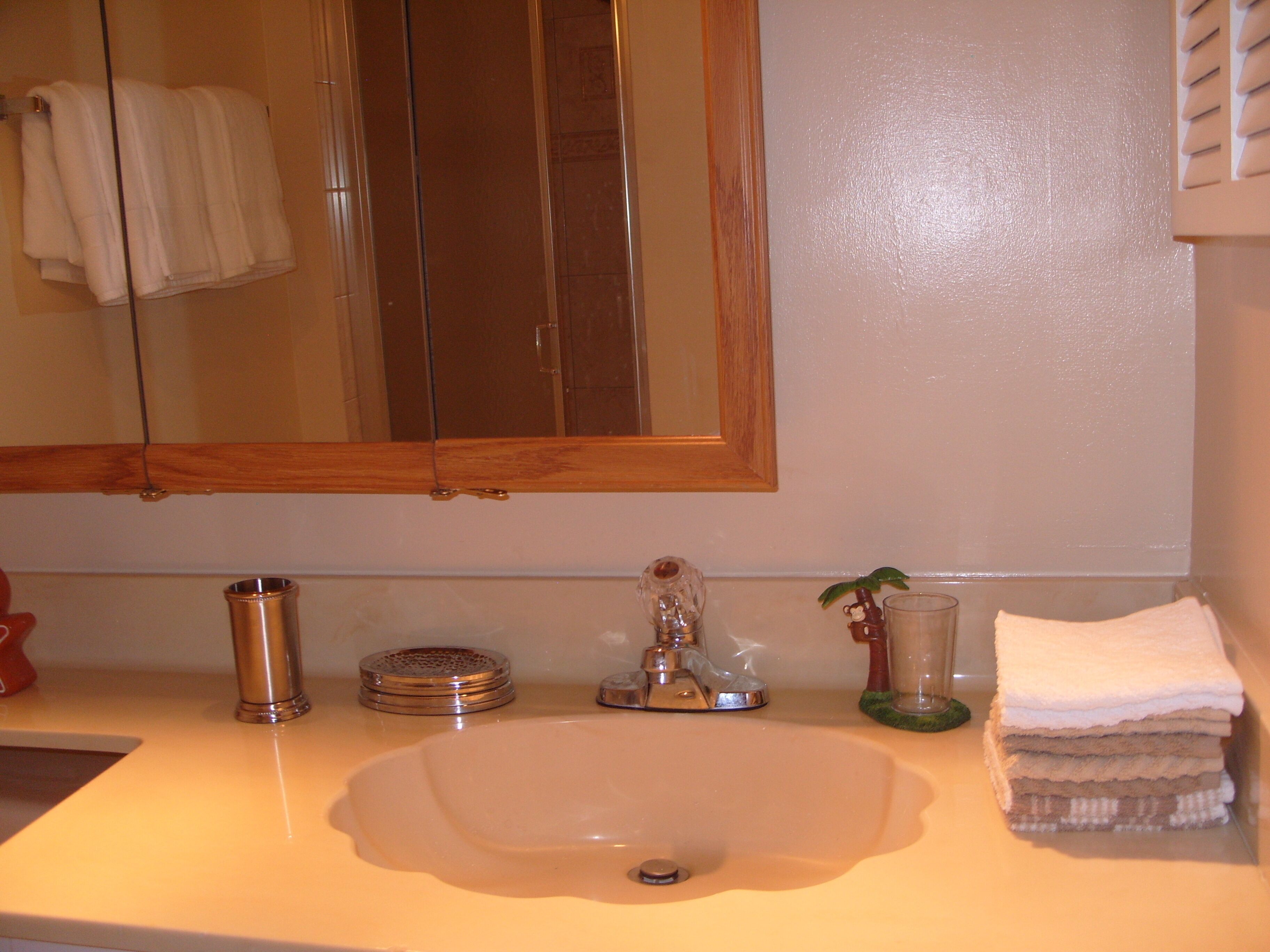 A bathroom with a sink, mirror, and towel rack.