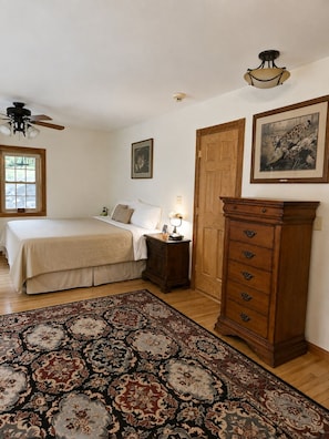 Une chambre à coucher avec un lit, une table de chevet, une commode et un grand tapis.