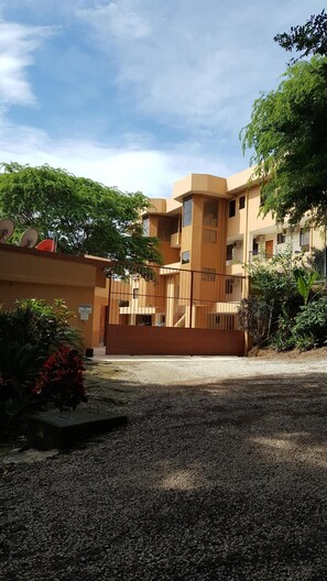 Stylish building with a flat roof and symmetrical facade, featuring a central staircase and lush green surroundings.