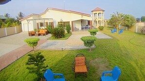Ein Haus mit überdachter Terrasse, einem kleinen Garten und einem turmartigen Aufbau.