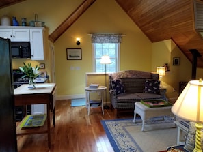 Cozy living room with a high ceiling, sofa, side table, and lamp, perfect for evening reading.