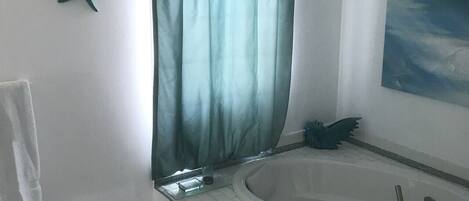 Ein Badezimmer mit einer Badewanne, einer Meerstern-Dekoration, einem Handtuchhalter und einem Bild an der Wand.