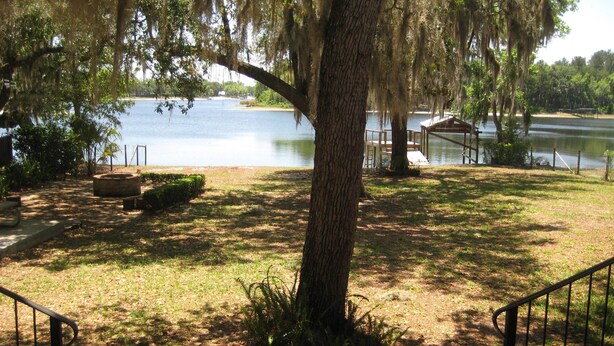 A view of a lake with a dock and a gazebo. - Island Lake Redwood Cottage With Canoe and Grill:  Relax, Swim, Fish, Ski, Enjoy (Fort McCoy)