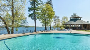 A clear swimming pool with lounge chairs and a gazebo overlooking a lake. - 🏖 Lake Winnipesaukee Vacation at Akwa Marina 🏖 Beach, Pool, Hot Tub, Beach Bar (Laconia)