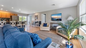 A modern living room with a sofa, a coffee table, and a potted plant. - Heated Pool + Hot Tub | Fenced Yard | Walk to Delaware Bay | Tides Away (Villas)