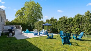 A backyard with a pool, blue Adirondack chairs, a barbecue grill, and a covered patio area. - Heated Pool + Hot Tub | Fenced Yard | Walk to Delaware Bay | Tides Away (Villas)