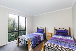 Une chambre avec deux lits, une fenêtre et une table de chevet.
