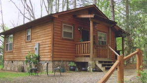 Eine Holzhütte mit Veranda und Steinuntergrund.