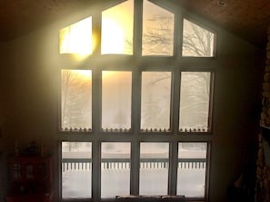 A room with a large window overlooking a snow-covered deck.