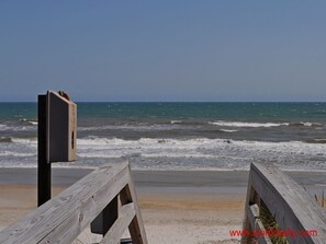 Walk along the beach on this weathered boardwalk, leading to the ocean's edge.