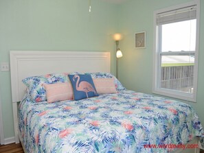 Una camera da letto con un letto, un comodino, una lampada e una finestra.