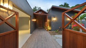 Ein modernes Haus mit hölzernem Tor, einem gepflasterten Weg und einer gut beleuchteten Eingangspartei.