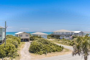 A coastal residential area with houses, a clear sky, and a view of the ocean. - Flip Flops - Cozy 2nd Row Home - Ocean Views! (Surf City)
