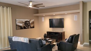A living room with a flat-screen TV, a fireplace, a sofa, and a recliner.