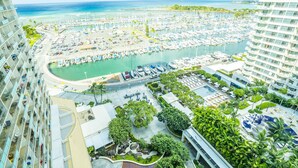 Un port de plaisance abritant de nombreux bateaux, un espace piscine et une végétation luxuriante.
