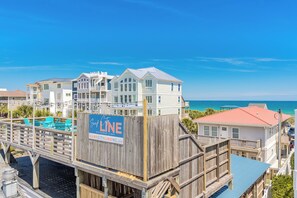 A beachfront property with multiple buildings, a wooden deck, and a sign for 'Surf City Line Restaurant & Bar'. - Hoos at the Beach - Lovely 4 BR Sea Star Village Townhouse; Ocean View! (Surf City)
