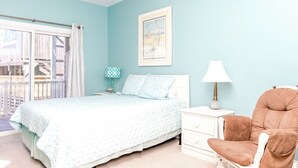 A bedroom with a bed, a nightstand, a chair, a window with curtains, and a framed picture on the wall. - Hoos at the Beach - Lovely 4 BR Sea Star Village Townhouse; Ocean View! (Surf City)