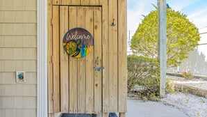 Puerta de madera con un letrero que dice 'Welcome', con una tortuga y elementos coloridos.