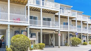 A multi-story hotel with balconies and a covered parking area. - Hoos at the Beach - Lovely 4 BR Sea Star Village Townhouse; Ocean View! (Surf City)