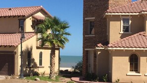 A residential area with two houses, one with a palm tree in front. - Beautiful Beach Condo with Sea Views in Beach/ Golf Resort with Wifi (San Felipe)