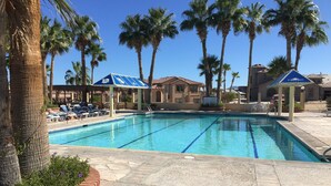A swimming pool with clear blue water, surrounded by palm trees and lounge chairs. - Beautiful Beach Condo with Sea Views in Beach/ Golf Resort with Wifi (San Felipe)
