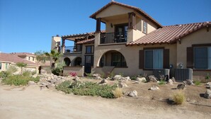 A two-story house with a balcony, arched windows, and a tiled roof. - Beautiful Beach Condo with Sea Views in Beach/ Golf Resort with Wifi (San Felipe)