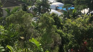 A tropical resort with palm trees, a beach, and a dome-shaped building. - Luxury Beach Front Accommodation  (Trinity Beach)