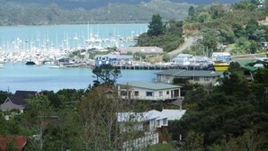 A marina with numerous boats docked, surrounded by residential buildings and lush greenery. - Private and pet friendly lockwood house (Okiato)