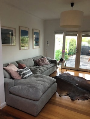 Relax in this stylish living room with a comfortable sofa, framed artwork, and a sliding door to an outdoor space.
