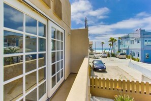 A residential building with large windows, a balcony, and a view of the street and ocean. - Oceanview from rooftop patio, parking, bikes, pets (San Diego)