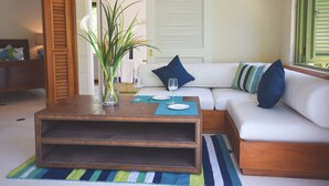 Una sala de estar con un sofá blanco, una mesa de centro de madera y un tapete a rayas.