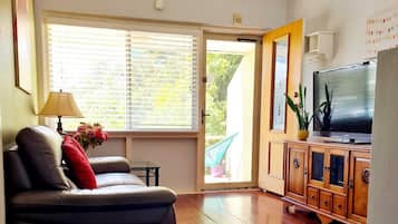 A living room with a sofa, a TV, and a wooden cabinet.