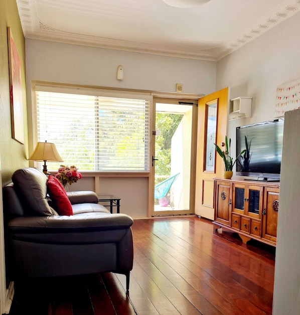 A living room with a sofa, a TV, and a wooden cabinet.