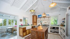 Una cocina amplia con una isla grande, armarios de madera y vistas al exterior.