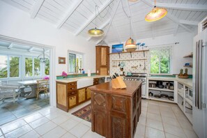 A spacious kitchen with a large island, wooden cabinets, and a view of the outdoors.