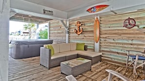 Un'accogliente area relax con un divano componibile, un tavolino e una decorazione a forma di tavola da surf sulla parete.