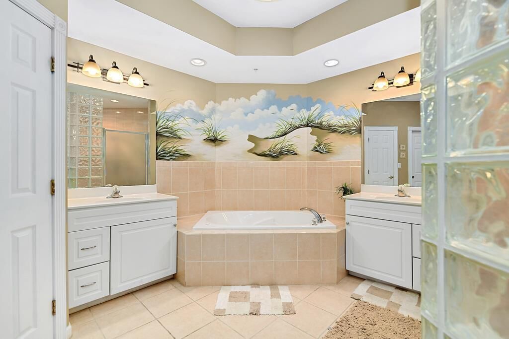 Ein modernes Badezimmer mit einer großzügigen Badewanne, zwei Waschbecken und einer dekorativen Wandmalerei.