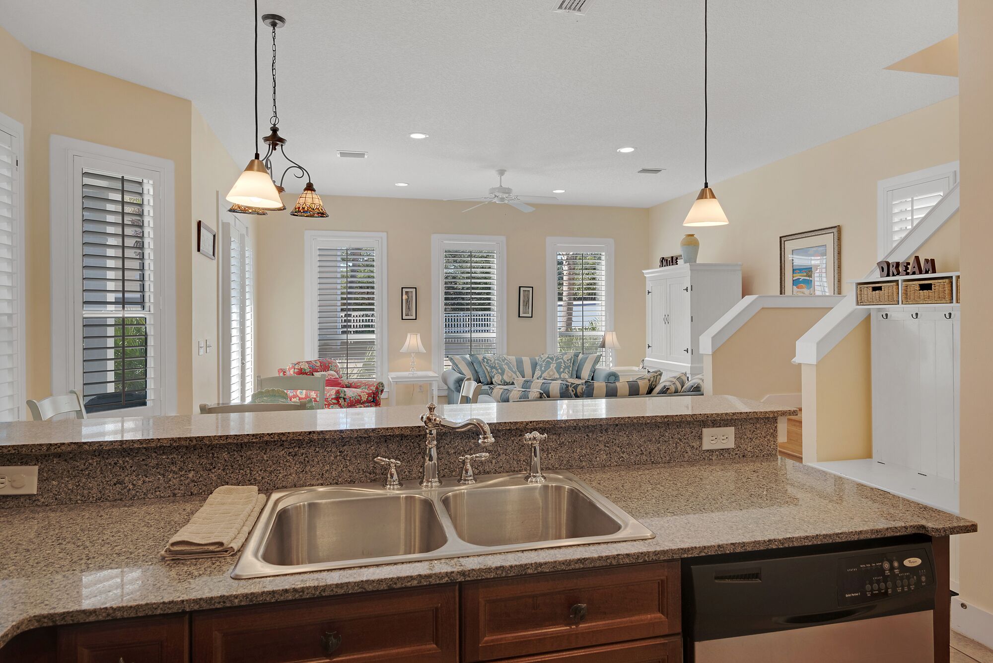 A kitchen with granite countertops, stainless steel sinks, and a dishwasher.
