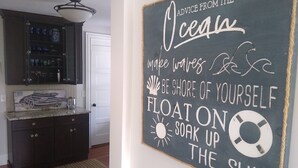 A kitchen with dark cabinets, a marble countertop, and a hanging light fixture. -  Water View 6-Bedroom Colonial, Hedgegate of Newport, 
Perfect for Large Groups
 (Middletown)