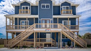 A two-story house with a balcony on each floor, a front entrance, and a sign indicating it is a rental property. - Down South | 450 ft from the beach | Private Pool (Virginia Beach)